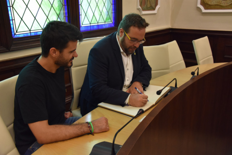 Juli Fernández signant el Llibre d'Honor de l'Ajuntament de Palau-solità i Plegamans